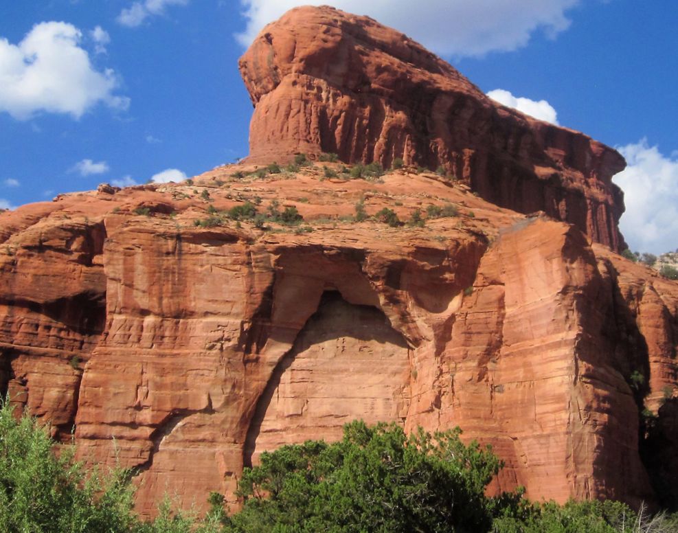 Hidden Entrance by Usha Lamat, a Sedona landscape photograph of a red rock cliff with a cave-like recessed opening beneath a blue sky